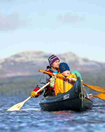 En gutt og en mann på kanotur i Femund Engerdal