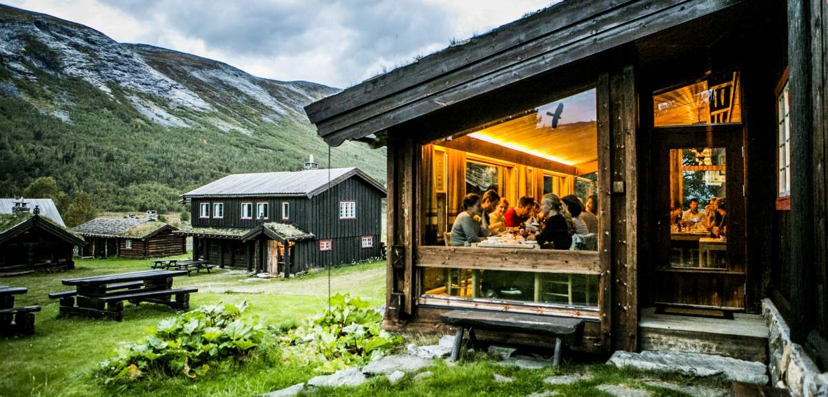 People around a table in the DNT hiking cabin Sota sæter, Breheimen