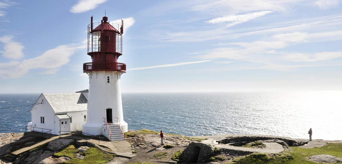 The white and red Lindesnes lighthouse in sunshine, on the coast of Lindesnes in Southern Norway