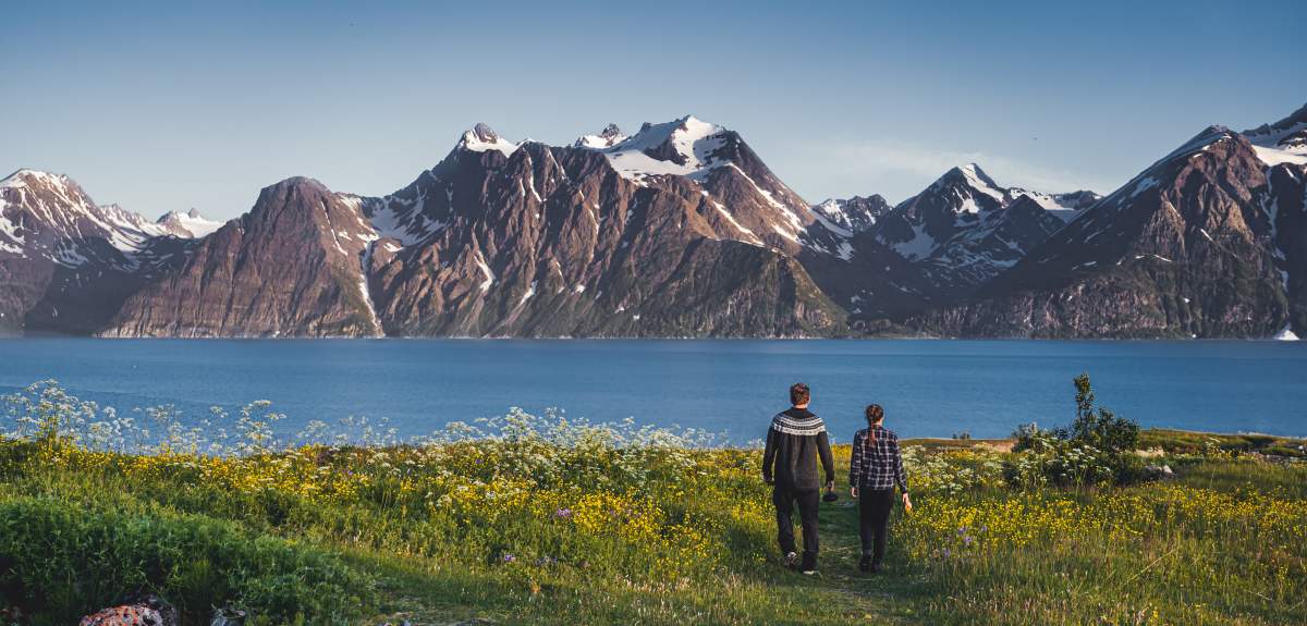 Two people in front of the Lyngenfjord Alps