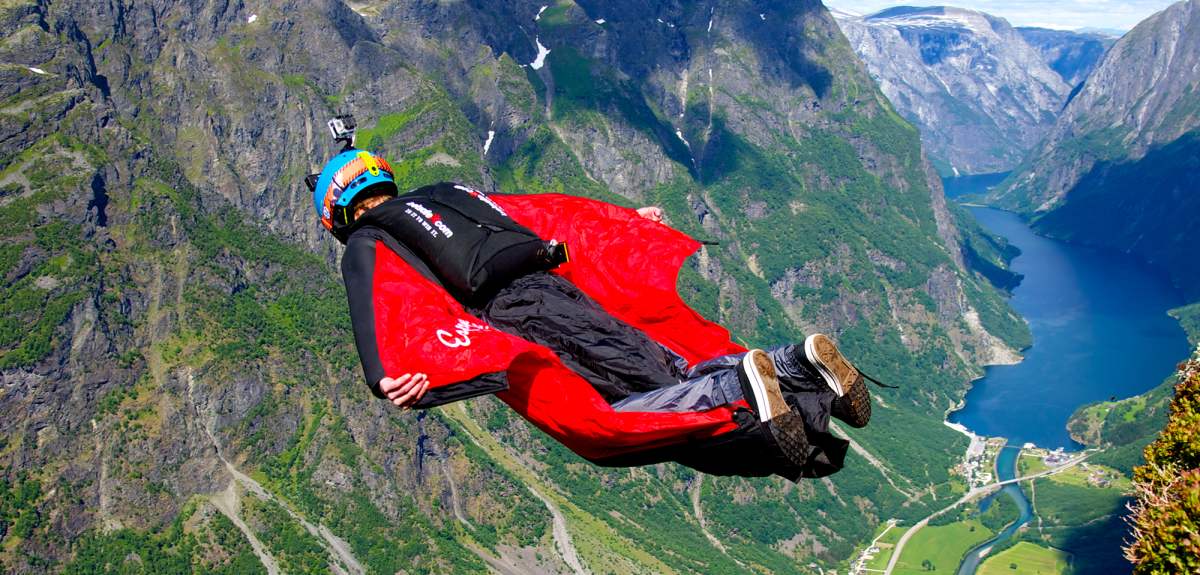 Una persona se lanza al vacío en un típico traje alado para hacer salto BASE sobre Voss, en la Noruega de los fiordos.