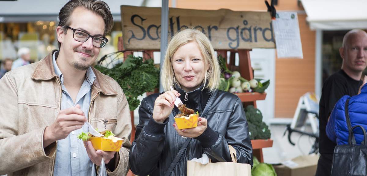 Man and woman eating food at festival in Trondheim