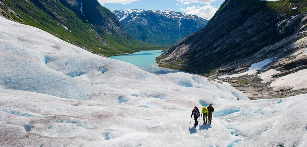 Three people hiking on the Nigardsbreen glacier in Fjord Norway