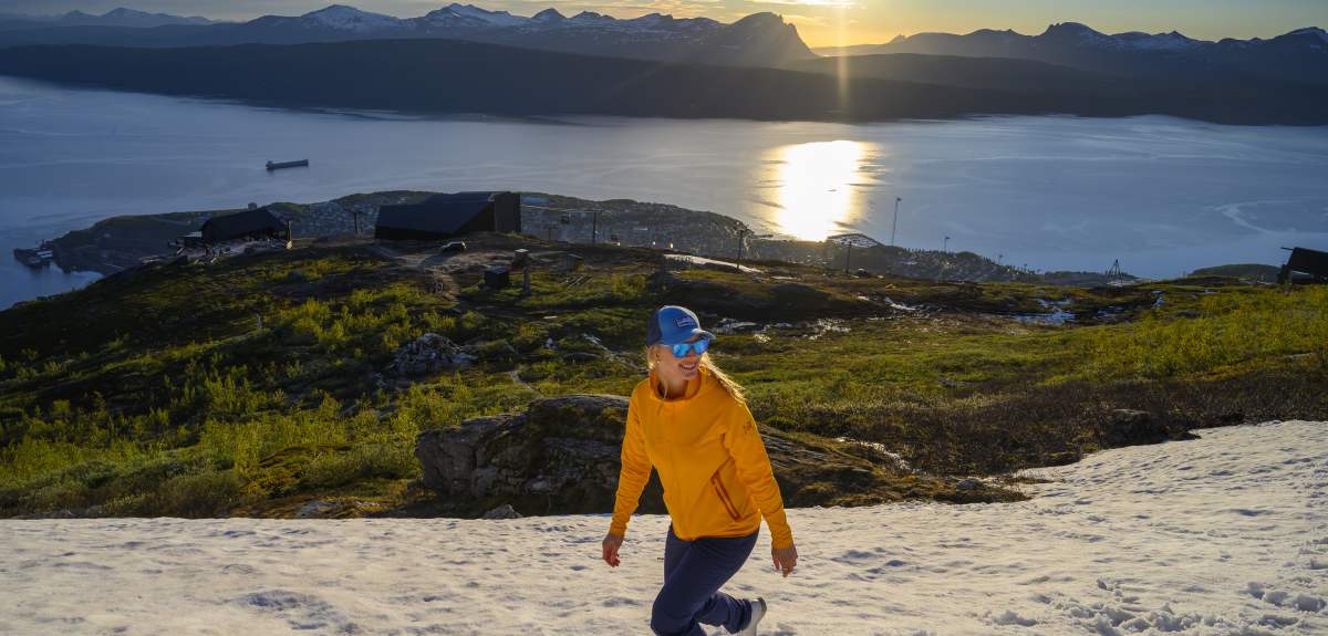 Una mujer disfruta de una caminata nocturna bajo el sol de medianoche en Narvik, en el Norte de Noruega.