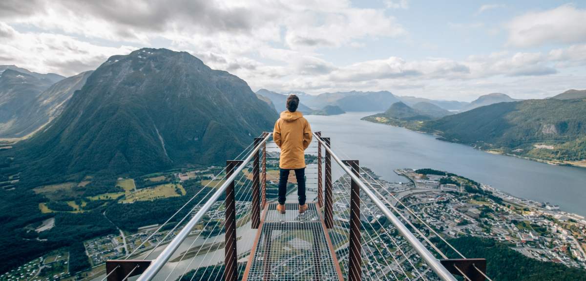 Человек на смотровой площадке Рампестрекен любуется видом на фьорд и горы Ондалснеса на Северо-Западе Региона фьордов