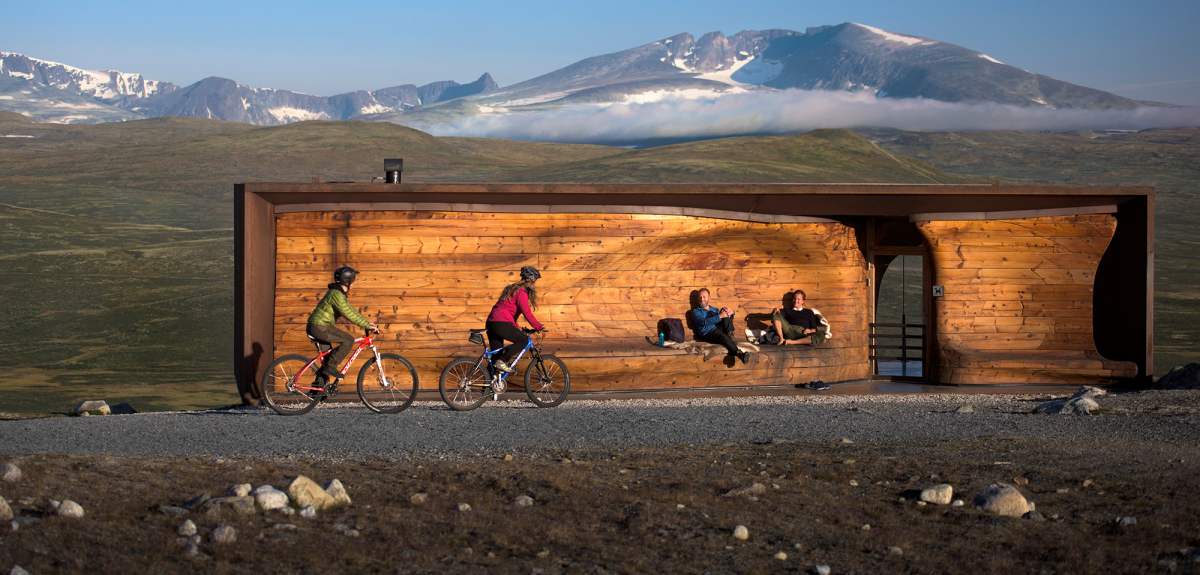 Two people cycling past viewpoint Snøhetta in Dovrefjell-Sunndalsfjella national park