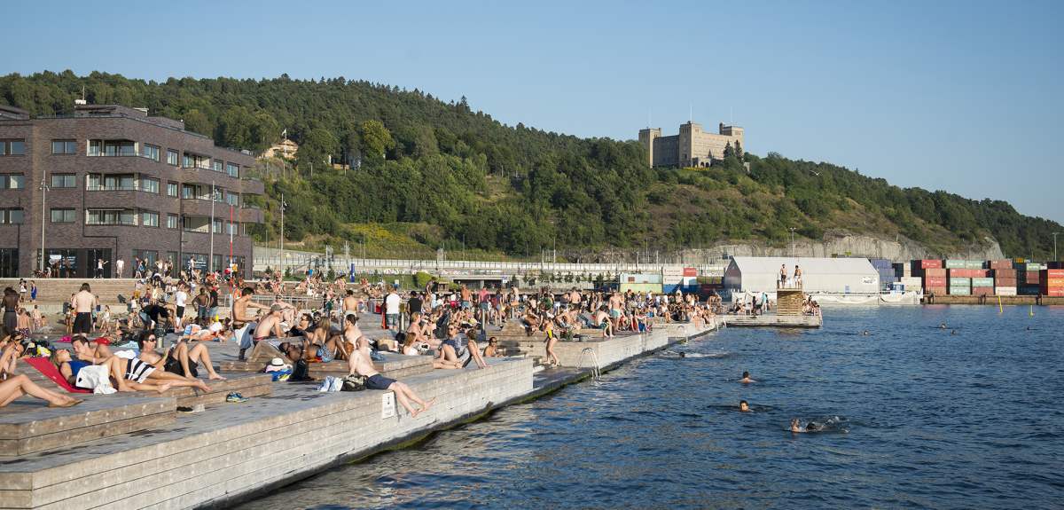 Imagen de la piscina de agua salada de Sørenga, en Oslo, llena de gente en un día soleado.