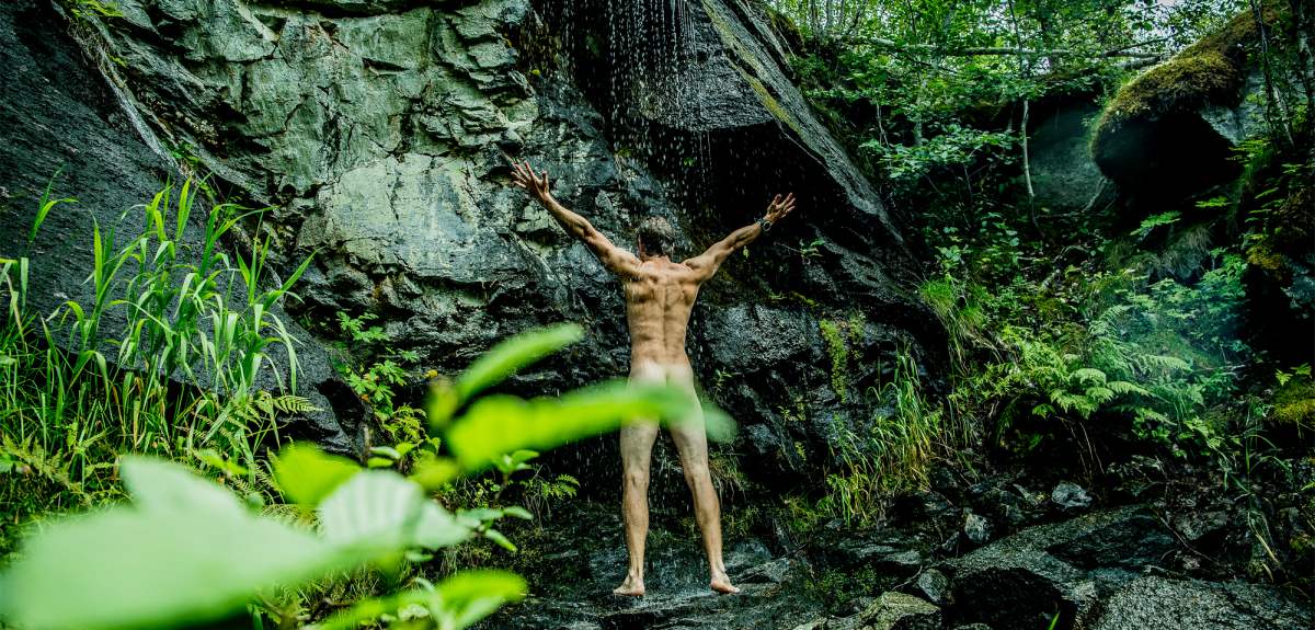 Green travel: A man showering naked under a waterfall in Innerdalen, Norway