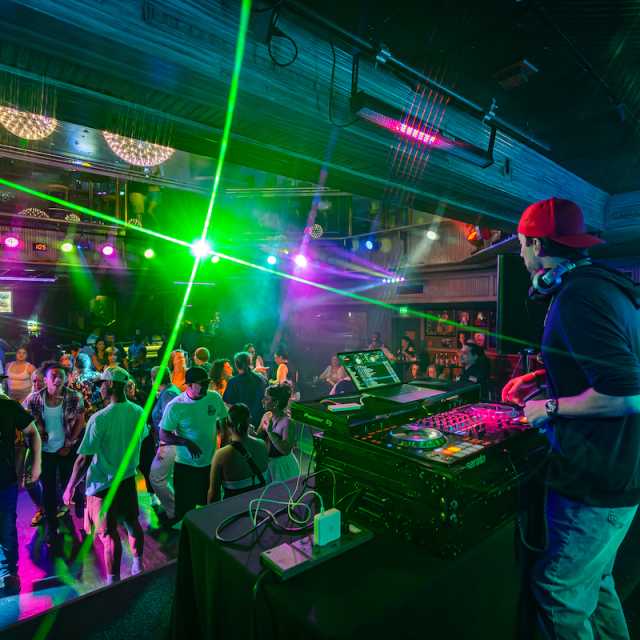 A group of people dancing in front of a DJ at Losers' Lounge at Don Laughlin's Riverside Casino & Resort.