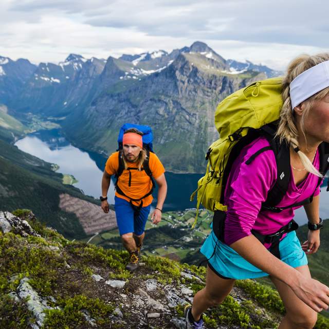 To personer på fjelltur med utsikt over Hjørundfjorden