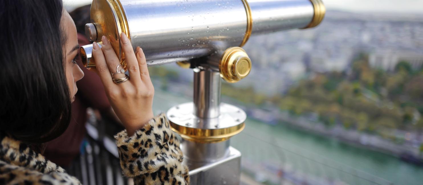 Woman looking through viewfinder in Paris