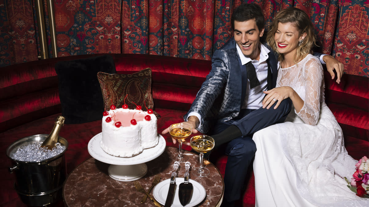 A newly married couple with a heart shaped cake and champagne at the Shag Room at Virgin Hotels Las Vegas