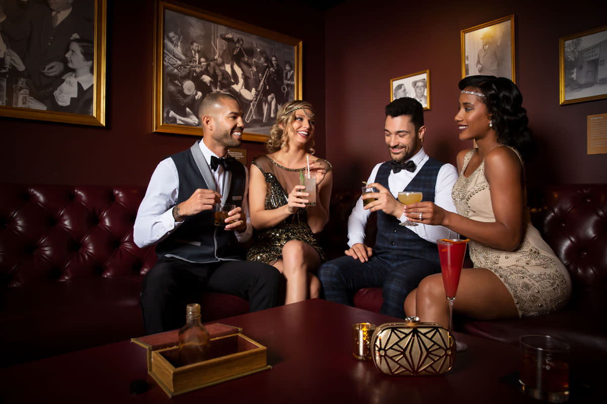 A group of people enjoying themselves with a drink at The Underground Speakeasy inside of the Mob Museum.