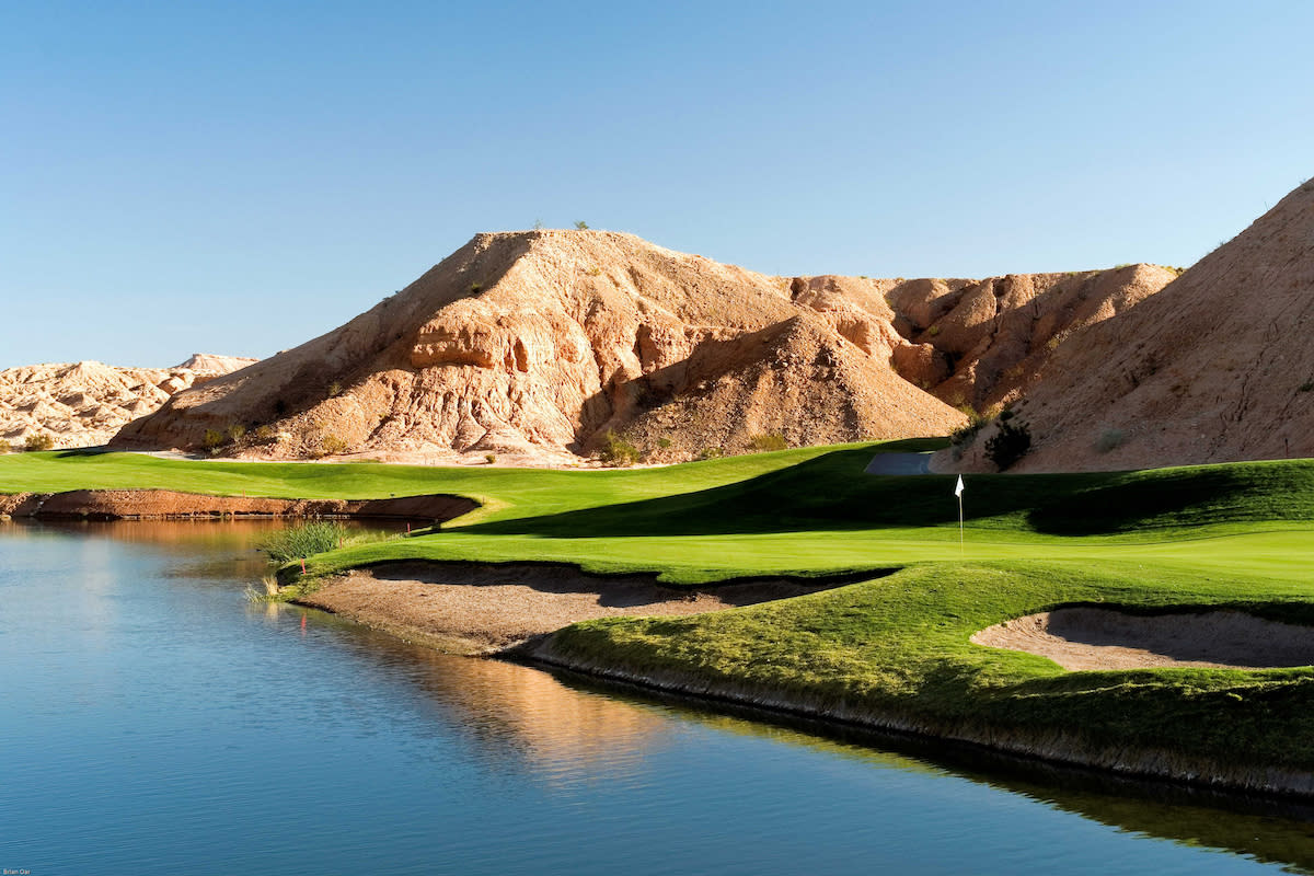 Breathtaking view of Oasis Canyons Golf Course by the water with a mountain hill in the backdrop in Mesquite, Nevada.