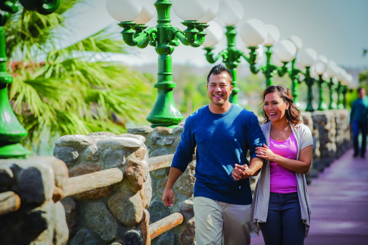 A couple has a lovely walk at the Laughlin River Walk.