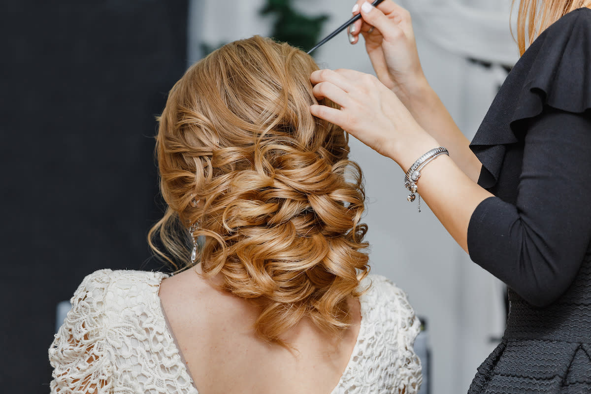 A beautiful bride getting her hair done on her wedding day.