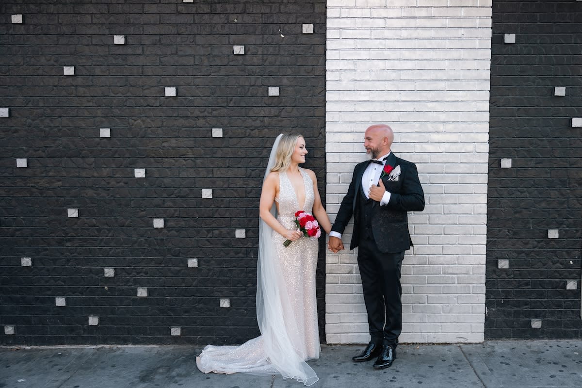 Couple posing in front of a black and white wall for wedding
