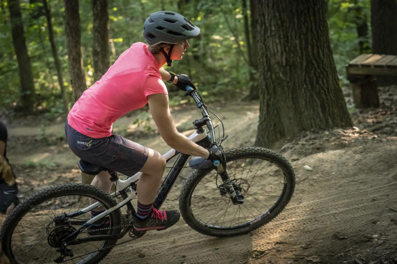 Mountain biker with a pink shirt on a trail just outside of Grand Rapids