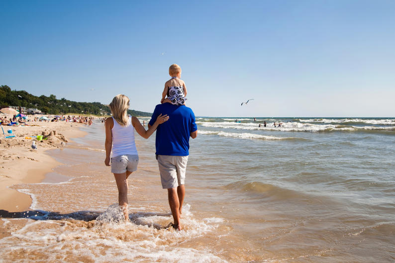 Family walking along the beach near Grand Rapids