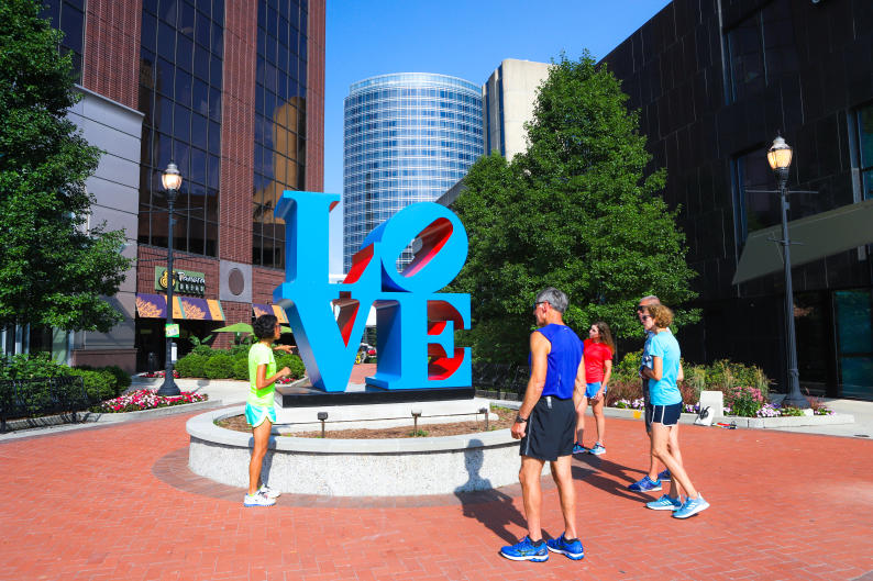 A running tour stops to admire LOVE by Robert Indiana.