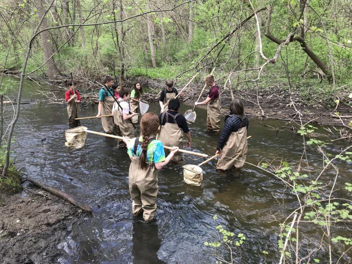 Grand Rapids students volunteers cleaning up a river