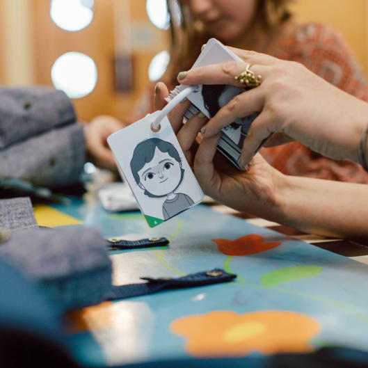 Child holding out the happy card from her feelings cards deck
