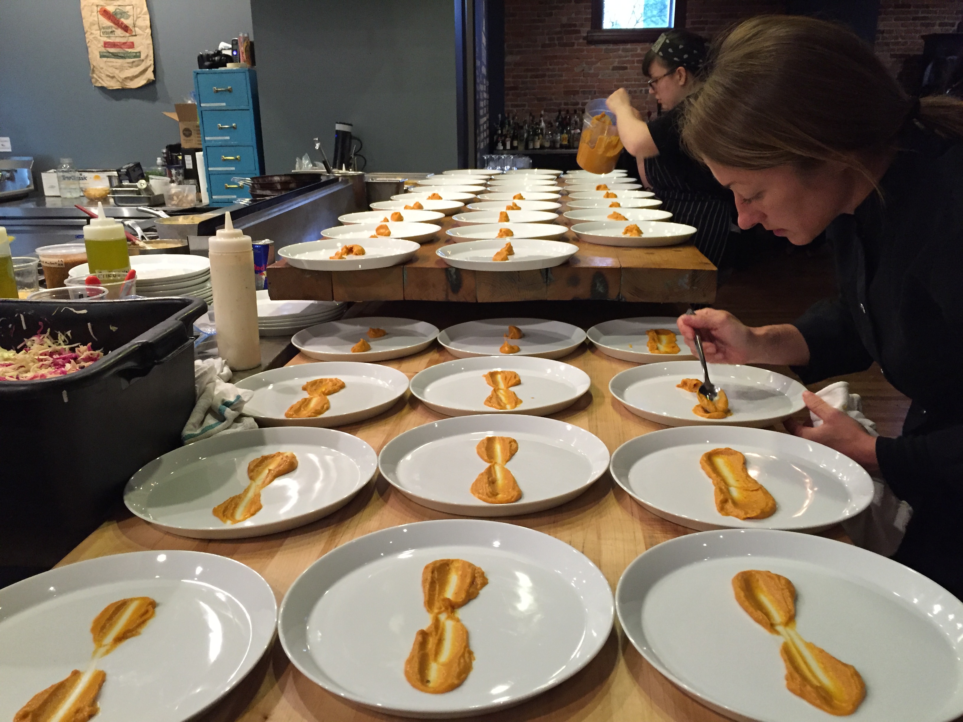 Dozens of plates smeared with sauce in preparation for cooking class