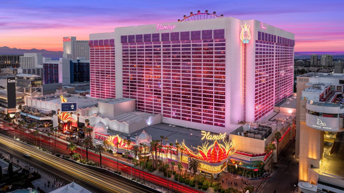 Exterior entrance of Flamingo Las Vegas hotel with pink lotus sculpture and palm trees