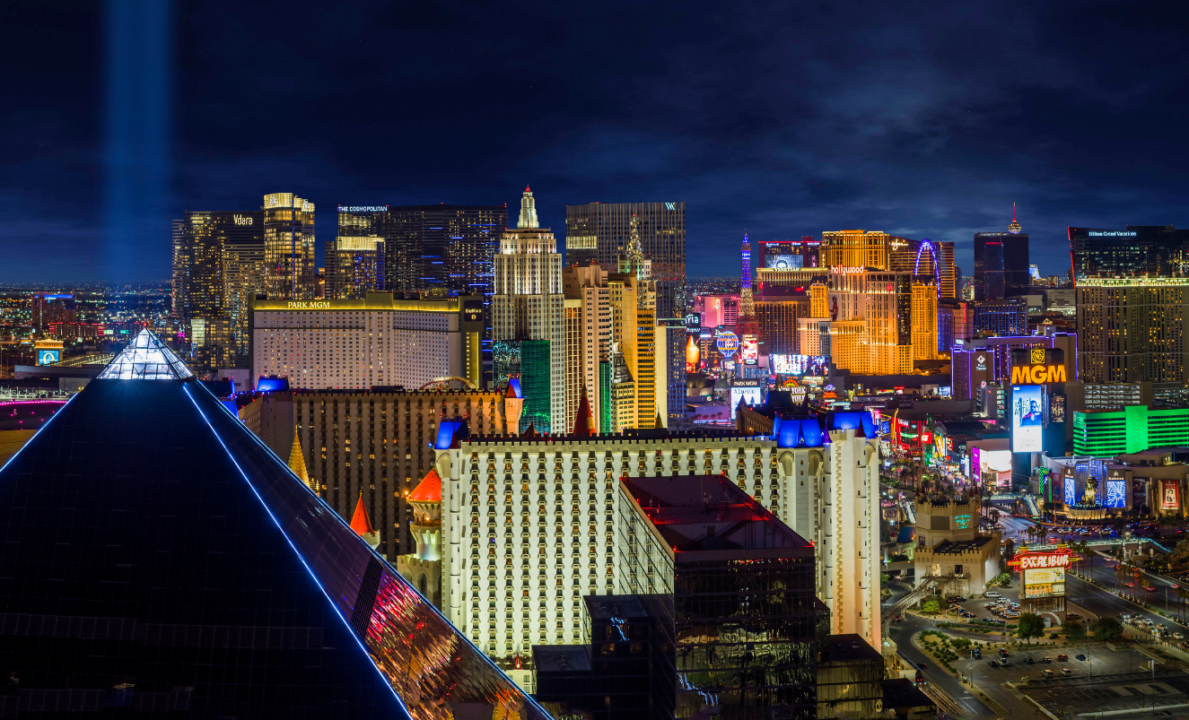 Large outdoor hotel pool with blue geometric tile patterns and resort towers in the background