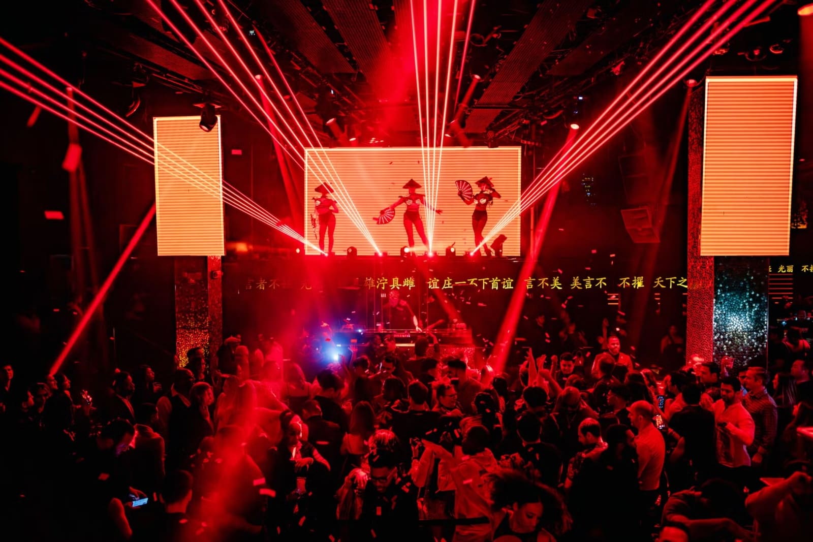TAO Nightclub interior with dramatic lighting, large Buddha statue, and packed dance floor