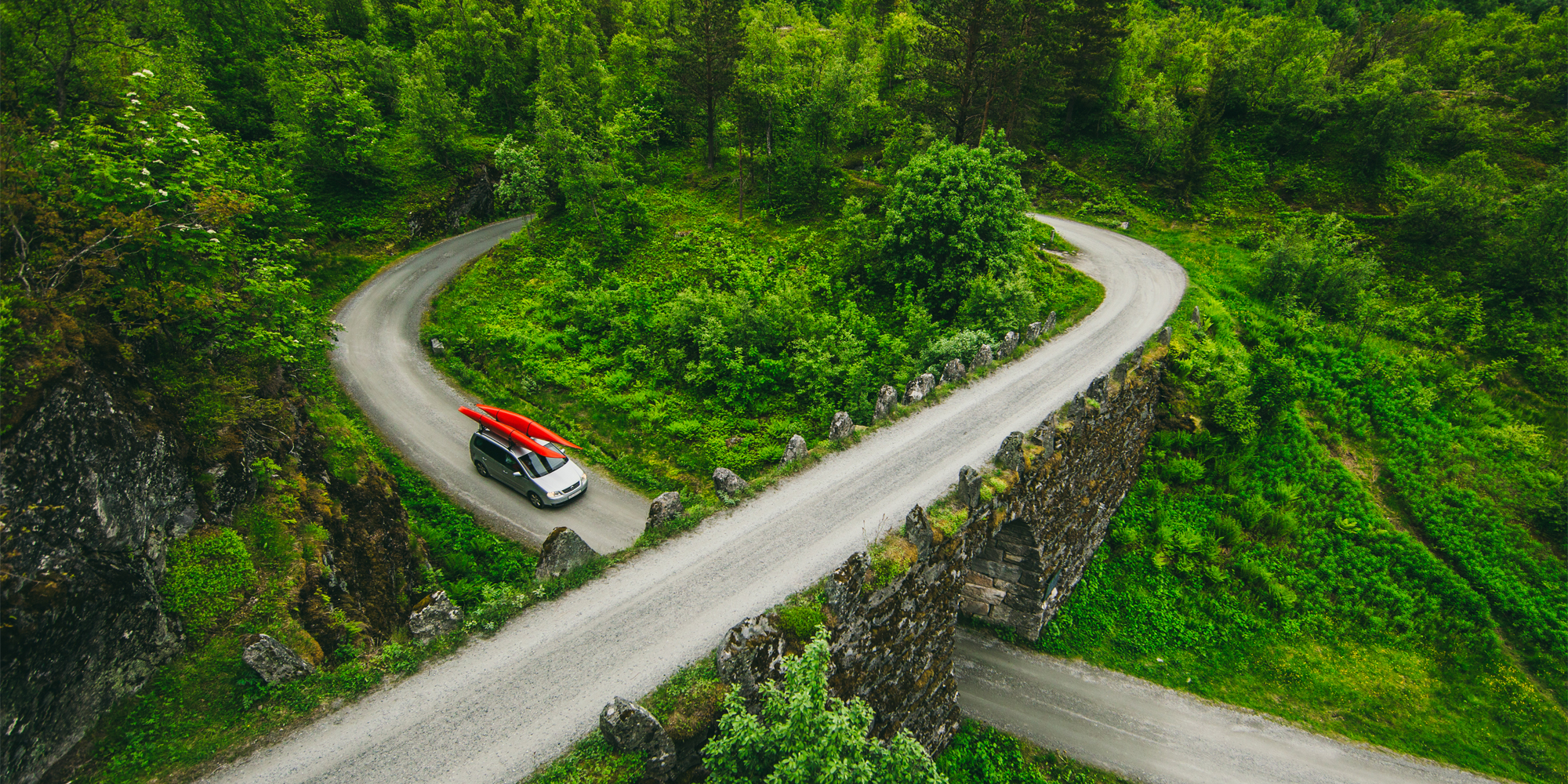 Road safety: A car with kayaks on the roof driving the ascending road loop Knuten in Geiranger, Fjord Norway