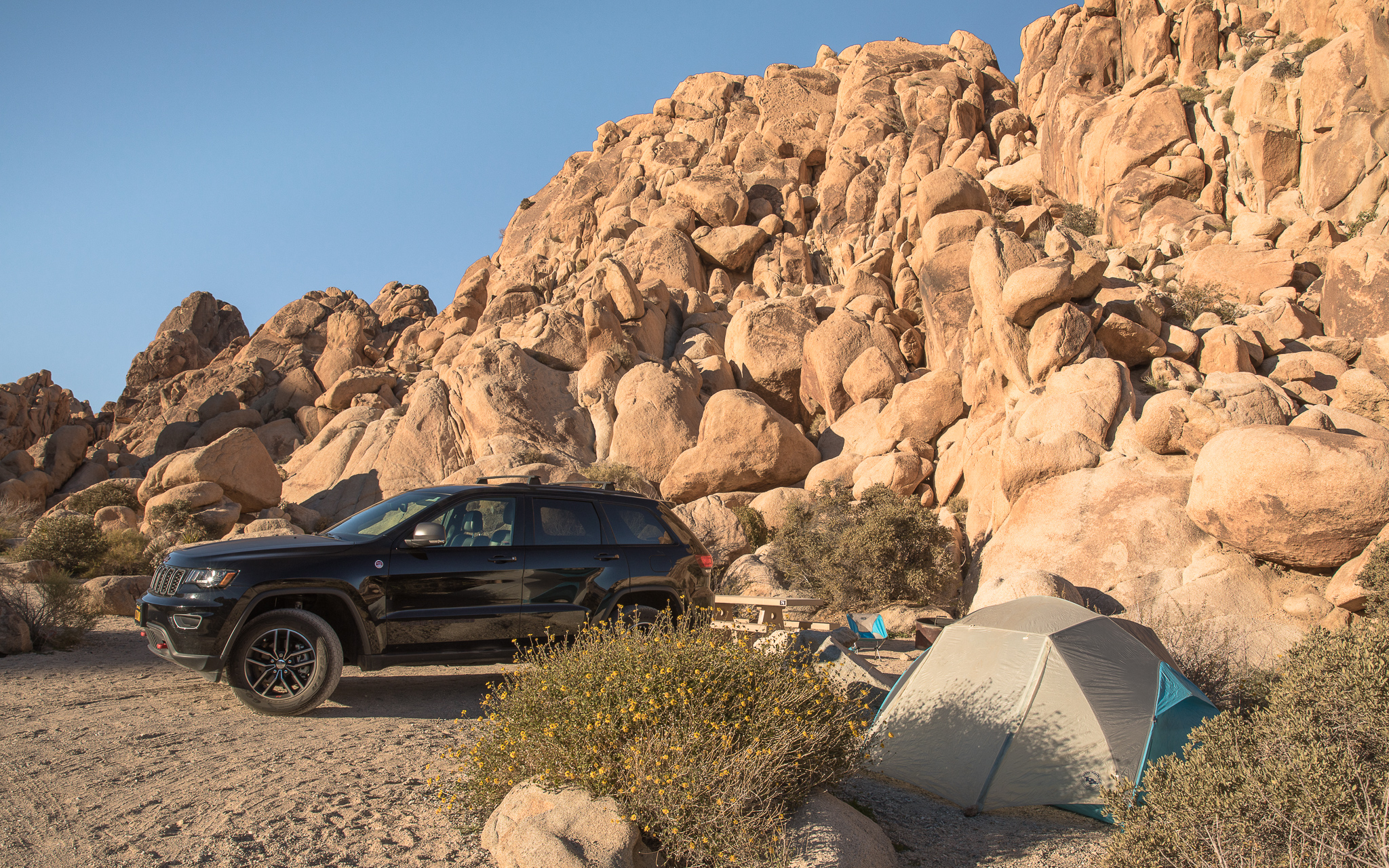 Car and tent at campsite in Indian Cove Campground in Joshua Tree National Park