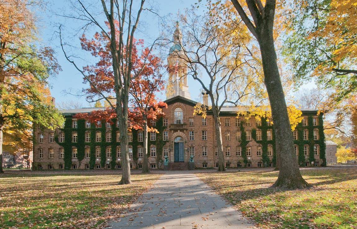 Outside view of Princeton University clock tower building between the fall trees