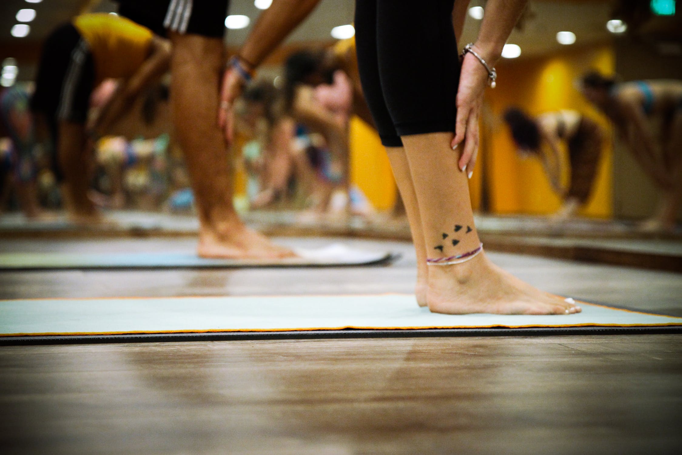 people reaching for their toes on mats in a yoga studio